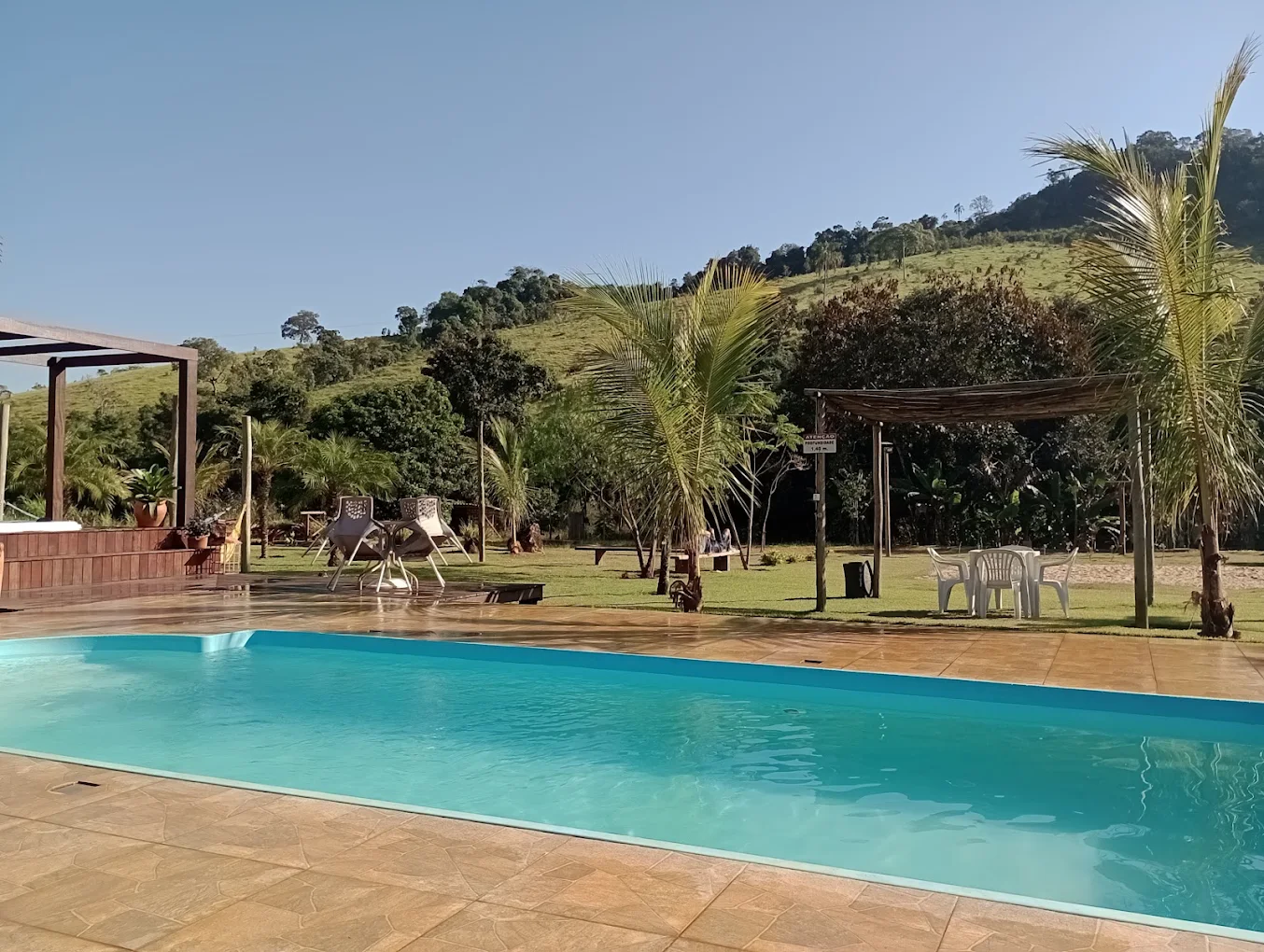 Piscina cercada de palmeiras e natureza